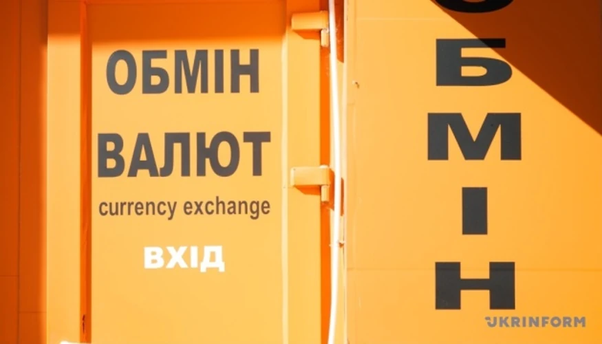 Банкноти долара та євро на тлі графіка курсу гривні